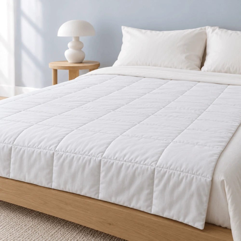 Couette lestée blanche posée sur un lit
