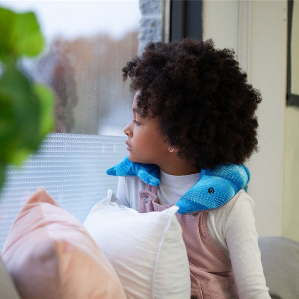 peluche dauphin lestée sur le cou d'une fillette